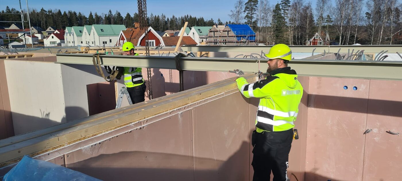 Hybrid steel beam and timber panel assembly on site